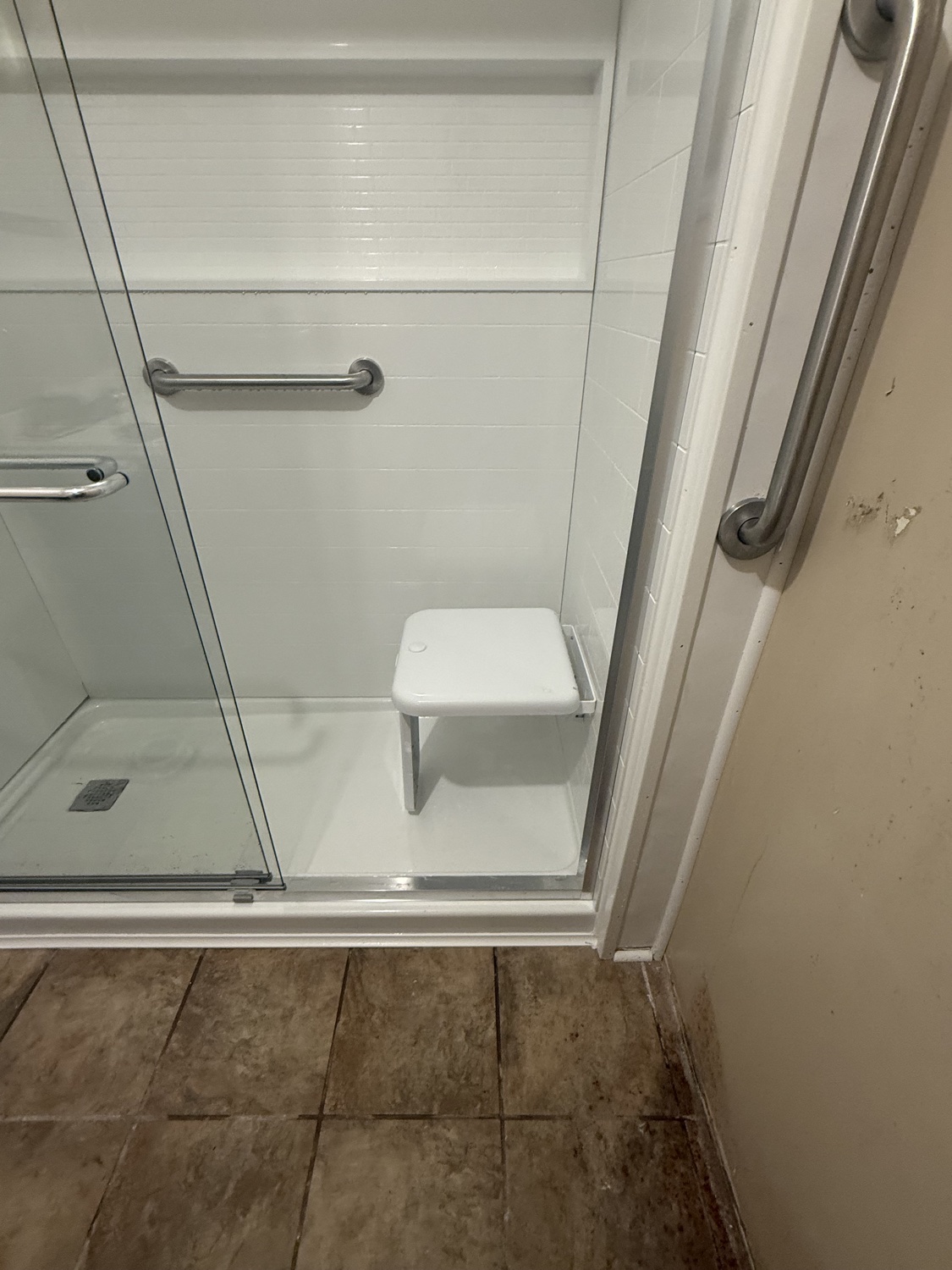 Walk-in shower with wall-mounted fold-down seat