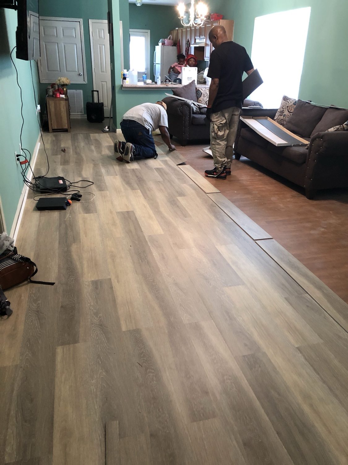 A-Quik crew installing plank flooring in living room
