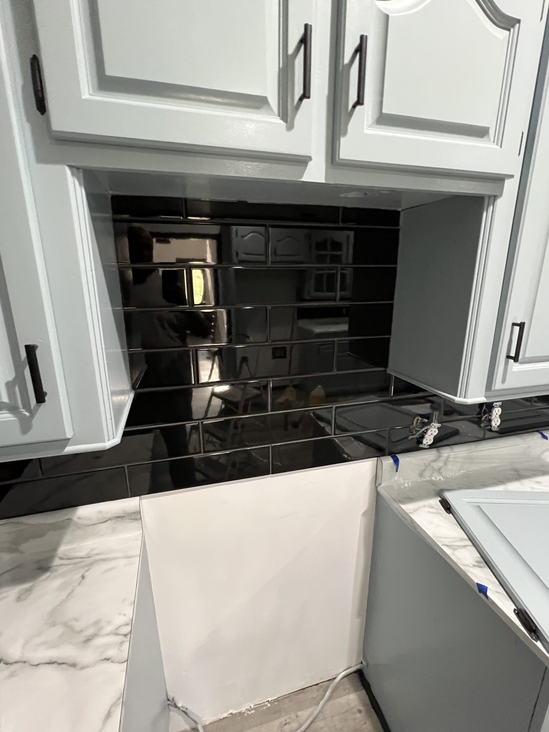 Finished black subway-tile backsplash, angled view
