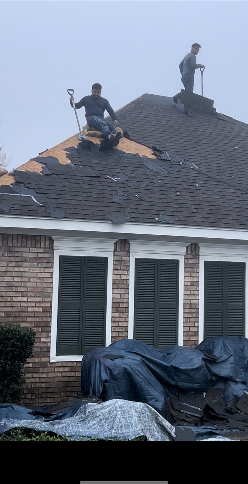 Crew tearing off storm-damaged shingles