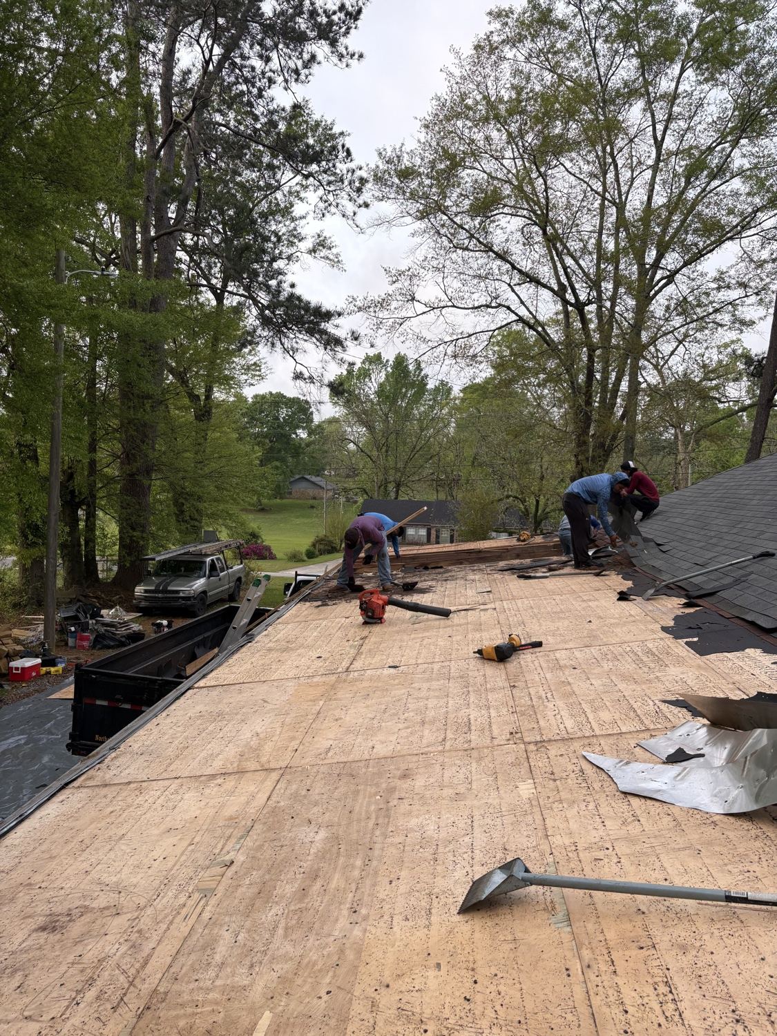 Roof repair in progress exposing damaged underlayment